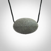 Greywacke stone pendant with Aotea Stone insert. Hand carved by Rhys Hall for NZ Pacific. Handmade contemporary jewellery for sale online.